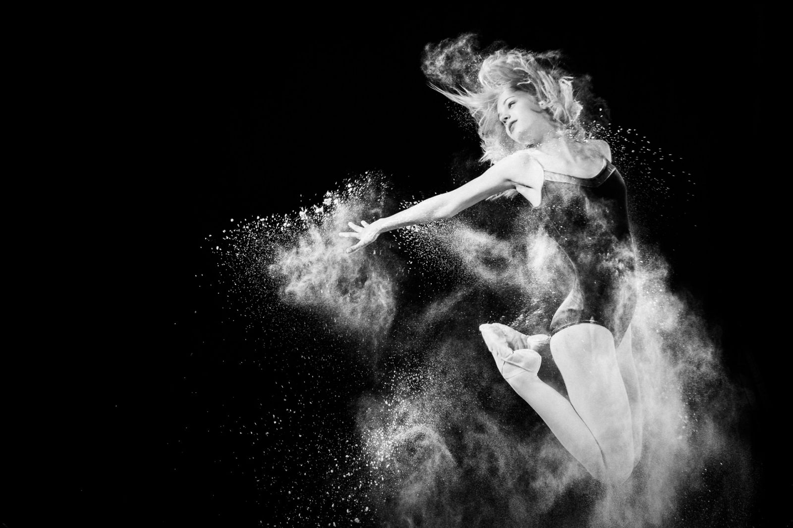 Ballet Dancer jumping with powder in black and white
