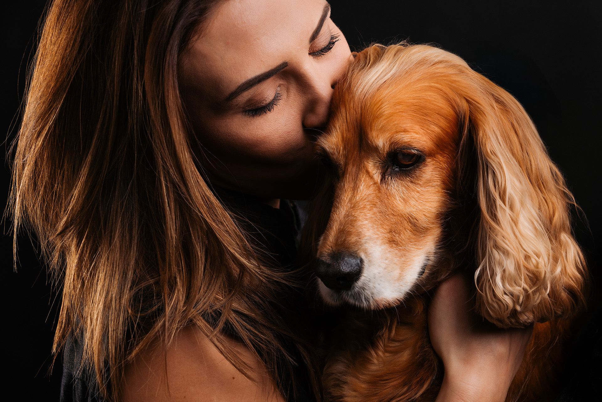Woman leaning against her dog in a close-up portrait